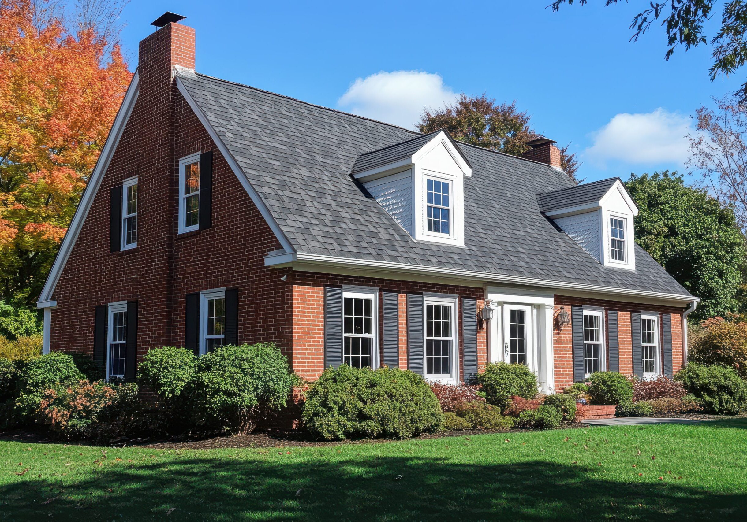 Classic red brick home in Norcross, Georgia, featuring white-trimmed double-hung windows, black shutters, and a glass front door.