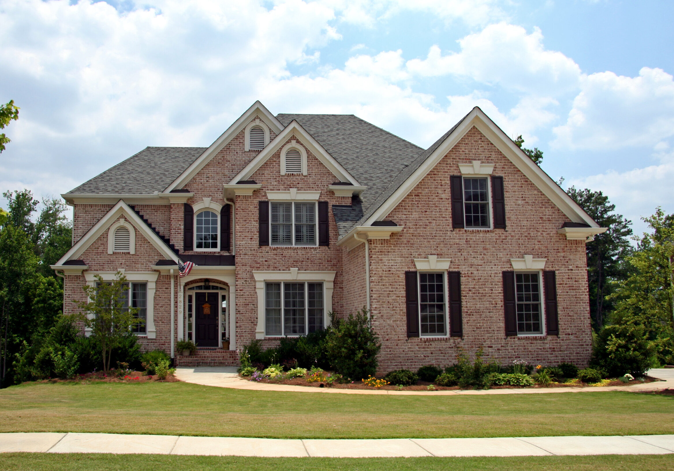 Traditional brick home in Tucker, Georgia, with double-hung windows, dark shutters, and a classic paneled front door.