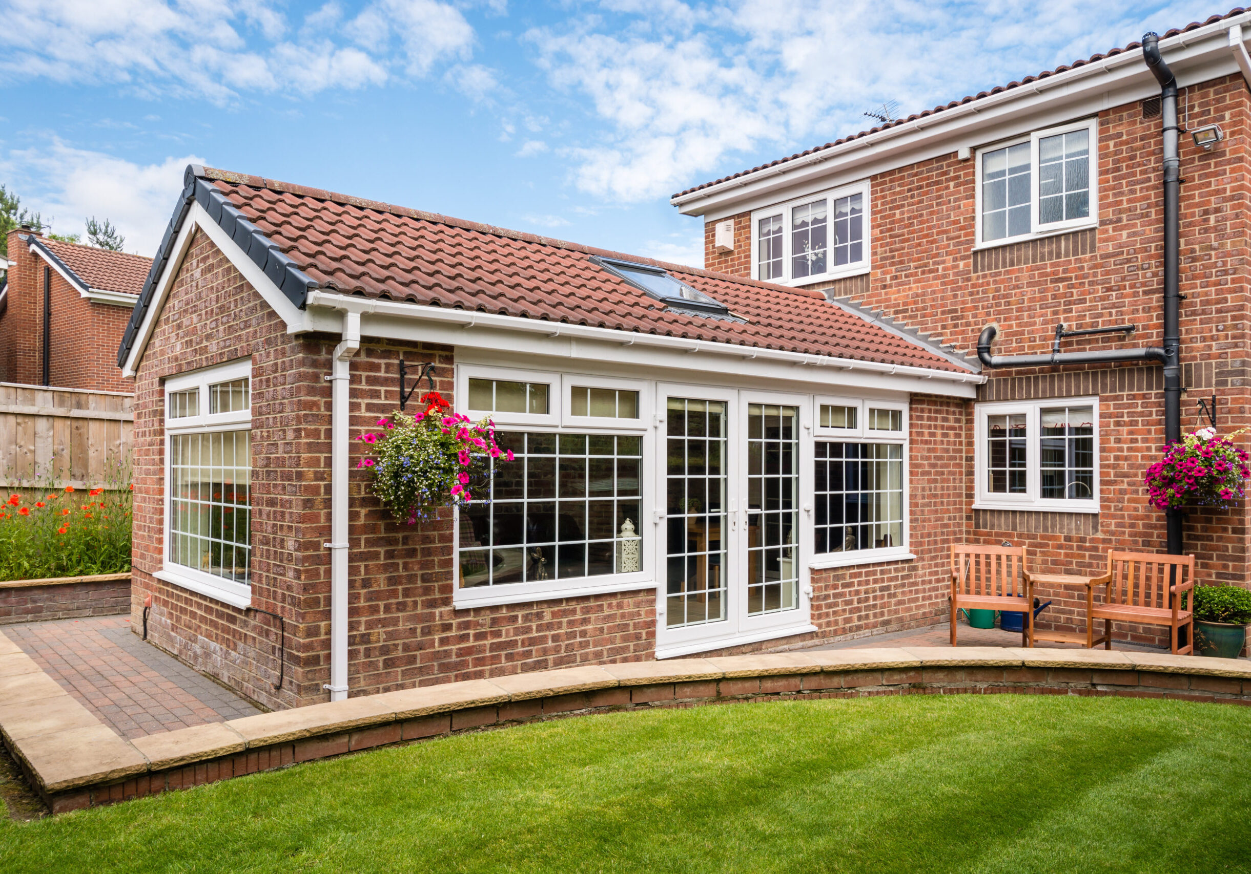 Modern Sunroom or conservatory extending into the garden, surrounded by a block paved patio